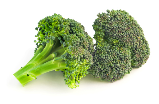 Two broccoli florets, pieces cut from the fresh green vegetable stalks, isolated on a white background. This food may be an ingredient in gourmet meals for healthy eating, and may be part of a vegetarian diet.