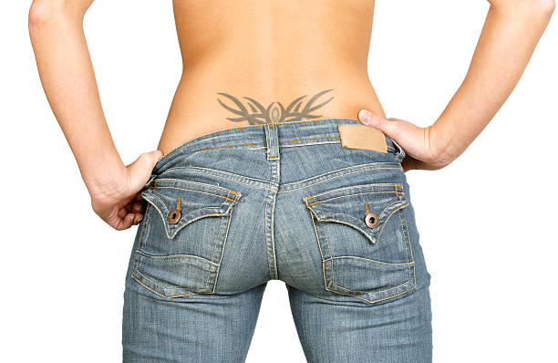 Backside of woman with tattoo on lower back  stock photo