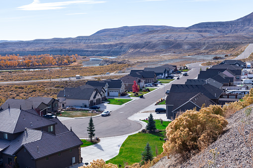 Green River, WY, USA - October 15th, 2022: View from above at the hills covered by autumn colors trees and the urban street near the park