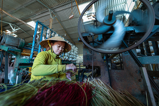 Woman is working on weaving machine for weave sedge mat - Phu Yen province, central Vietnam