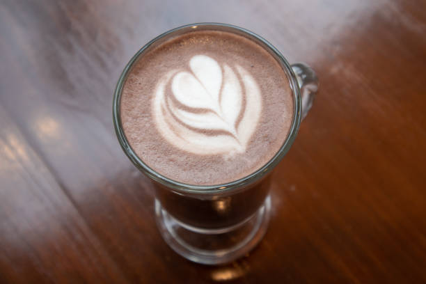 heißer kakao dekoriert mit herzförmigen brüsten und natur auf einem holztisch. - hot chocolate hot drink high section color image stock-fotos und bilder