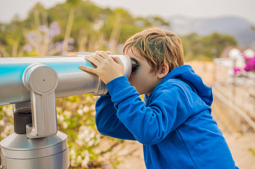 Binoscope. Stationary city binoculars. A boy looks at the city through a binoscope.