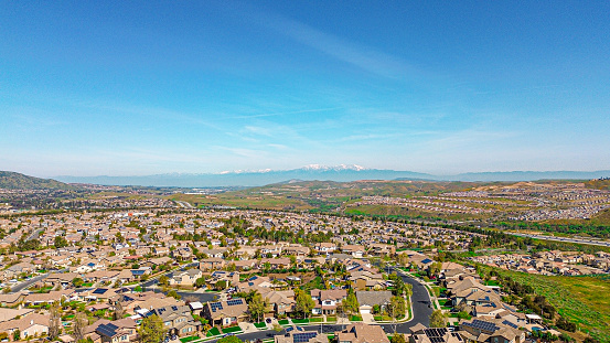 The urban area of Corona, California from the vantage of a drone.  The neighborhood nestle up against the poppy covered hillsides.