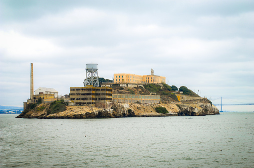 Picture of Alcatraz Island from the water surrounding it. Picture was taken on a cloudy day while taking a trip around the island on a boat.  The history of this island is not only fascinating but intriguing once viewed up close.