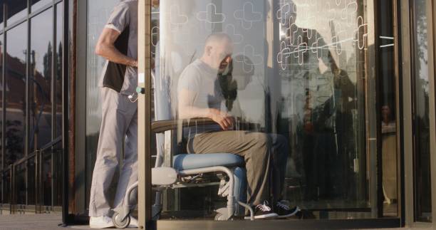 istock Two doctors take elderly man with disability to the clinic 1725283549