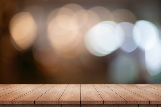 istock Empty wooden table top with lights bokeh on blur restaurant background. 1725292418