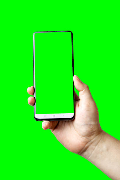 istock Male hand holding smartphone with blank screen isolated on green background. 1725295502