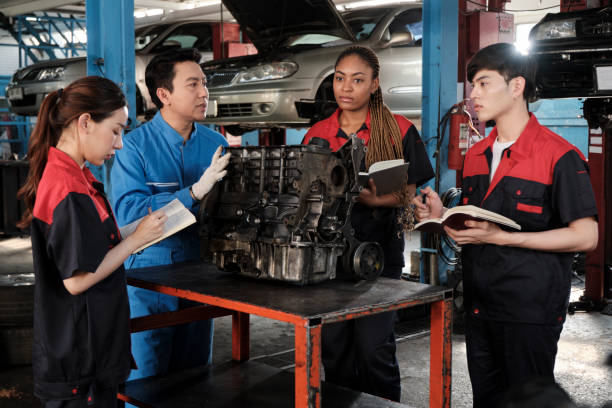 istock Supervisor engineer is teaching mechanic workers about car engines at a garage. 1725377268
