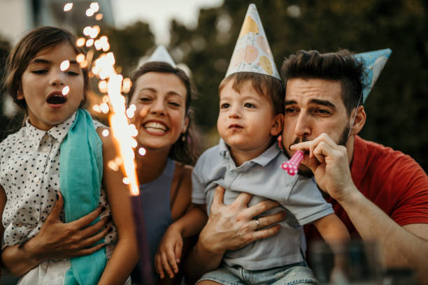 A family gathers under the open sky to commemorate a birthday in style, as they enjoy a delightful cake on a garden party table adorned with festive decorations