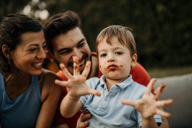 A family gathers under the open sky to commemorate a birthday in style, as they enjoy a delightful cake on a garden party table adorned with festive decorations