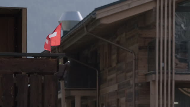Swiss flag blowing in the wind in the small village of Zermatt