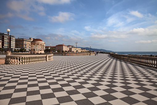 Leghorn (Livorno), Tuscany, Italy: landscape of the promenade Mascagni Terrace, a picturesque seashore on the Ligurian sea with black and white checkered pavement and columned bannister