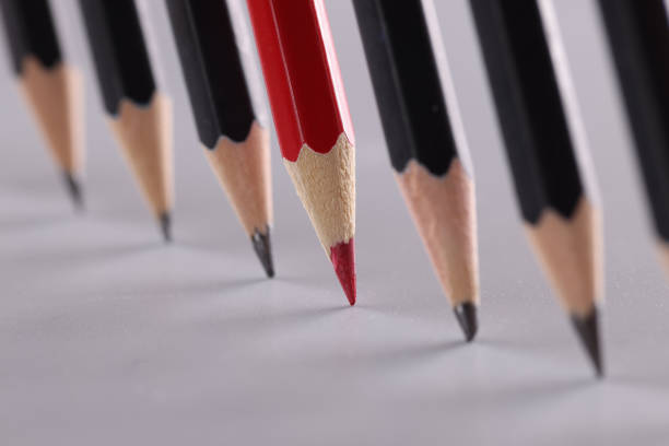 Red pencil stands out from crowd on gray background. Initiative strategy and disagreement concept