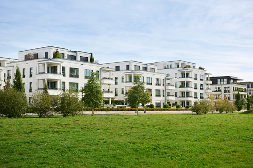Photograph of contemporary townhouses with a lawn in the foreground,  Düsseldorf, Germany.