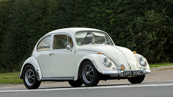 Bicester,Oxon.,UK - Oct 8th 2023: 1966 white Volkswagen Beetle classic car driving on an English country road.