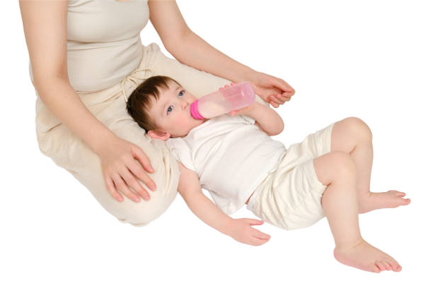 istock Happy baby with mother drinks milk from bottle on studio, isolated on white background. Resting child with mom eats formula. Kid about two years old (one year nine months) 1725516197