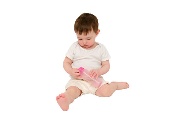 istock Baby breaks a milk bottle while pressing the nipple, studio, isolated on white background. Kid about two years old (one year nine months) 1725516204