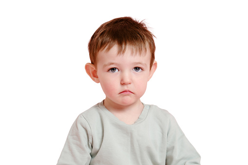 Sad toddler baby on studio, copy space, isolated on white background. Unhappy child boy face close-up, isolated on white background. Kid age one year eight months