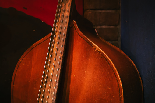 Senior man playing double bass on stage with his band on gig