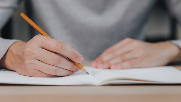 istock Close up hands of man holding pencil with writing on notebook, Learn from home, Work from home 1725541955