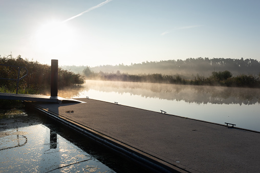 Floating jetty at the banks of river Peene in a nature reserve at Voelschow Berg near Demmin at sunrise