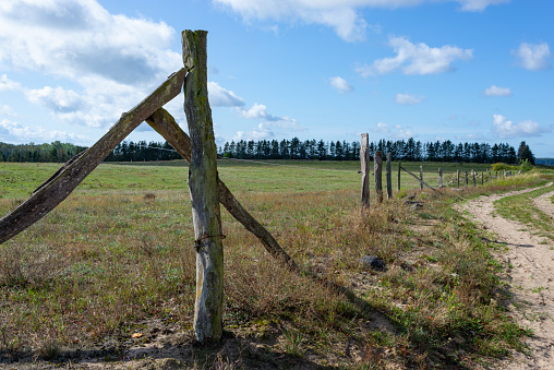 Details of a wooden fence at a sandy path leading to village Upost