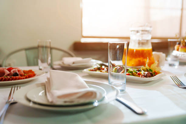 White round plate with serving napkin on table. Table setting for a banquet. Cutlery for the dining room.