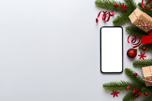 istock Digital phone mock up with rustic Christmas decorations for app presentation top view with empty space for you design. Christmas online shopping concept. Tablet with copy space on colored background 1725604566