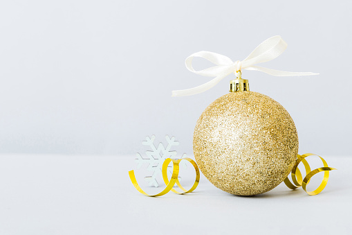 Christmas ball on colored background. decoration bauble with ribbon bow with copy space.