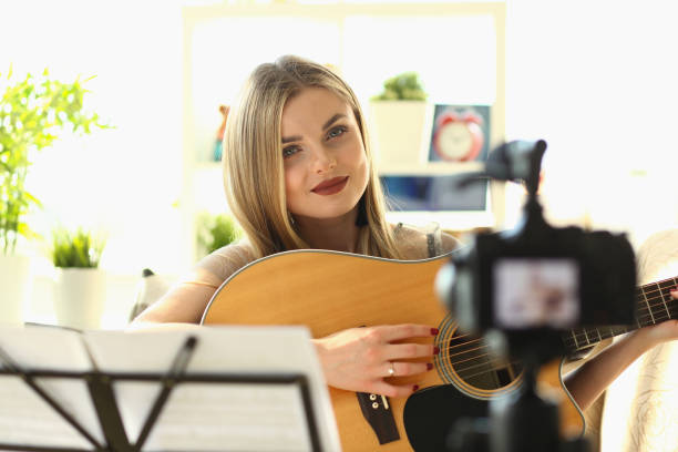 istock Young influencer blogger plays guitar filming an educational vlog 1725611279