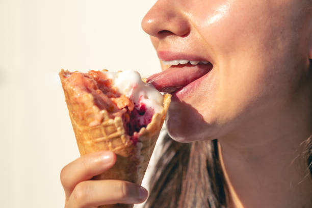 istock Close-up female lips eating a ice cream cone. 1725624768