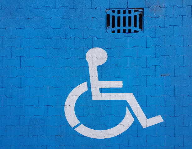 istock Road marking sign on a blue background denoting parking for a disabled vehicle. The convenience of parking a vehicle. The journey of people with disabilities in a wheelchair. Free space for the needy 1725626438