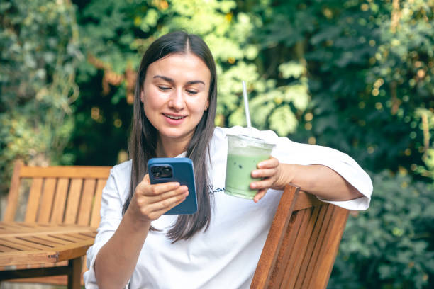 istock A woman drinking matcha latte coffee and using smartphone in a cafe 1725626996
