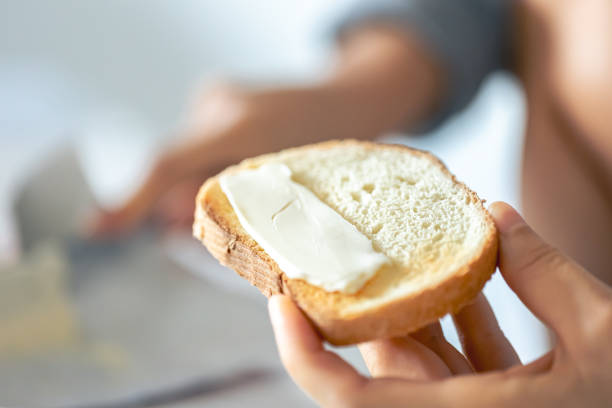 istock A piece of bread with butter in a woman's hand. 1725638283