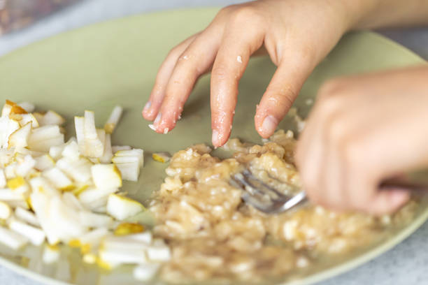 istock A female with a fork crushes bananas in a plate. 1725646241