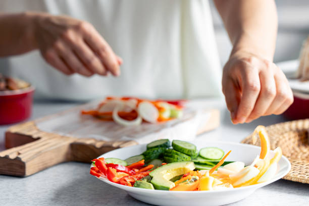 istock Woman preparing spring rolls in rice paper on kitchen table. 1725654325