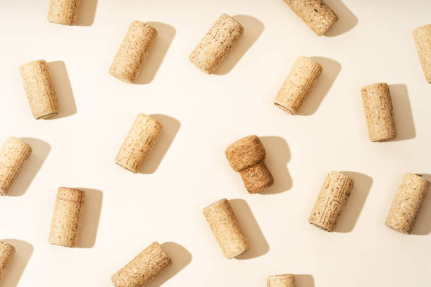 istock Pattern with wine and champagne corks, sun glare from a champagne bottle on a beige background with hard sunlight and shadow. Background with wooden bottle cap, top view, minimal flat lay. 1725668325