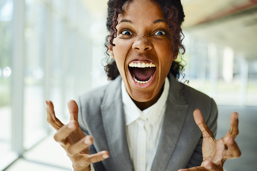Portrait of frustrated African American businesswoman screaming and looking at camera.