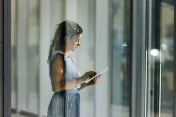 Young female entrepreneur using digital tablet in a hallway.