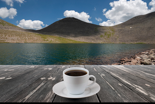 Close up white coffee cup on wood table and view of nature background.