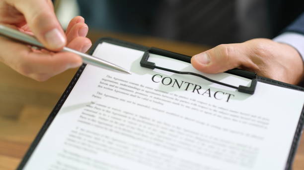 istock Businessman is holding tablet in hand and pointing with pen at contract documents 1725687201