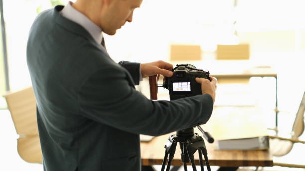 istock Photographer in studio adjusts settings of camera 1725691759