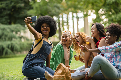 multiracial friends partying in the park making selfie