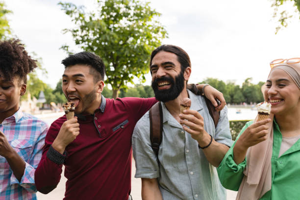 アイスクリームを食べる公園の若い多民族旅行者 - エラスムスの学生 - - group of people people family multi ethnic group ストックフォトと画像