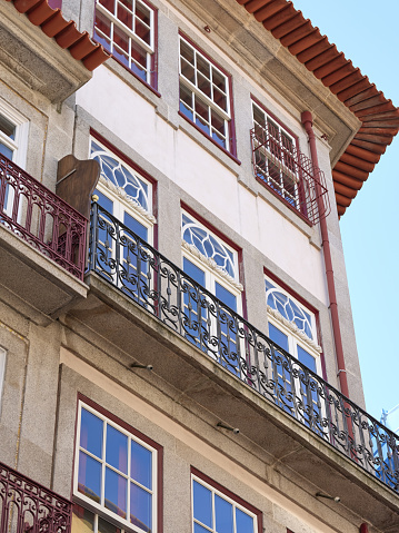 Typical Portuguese houses, covered with colorful azulejos, in the historic part of the city of Porto, Portugal. Details of house facades, windows, balconies, railings, colored ceramics.