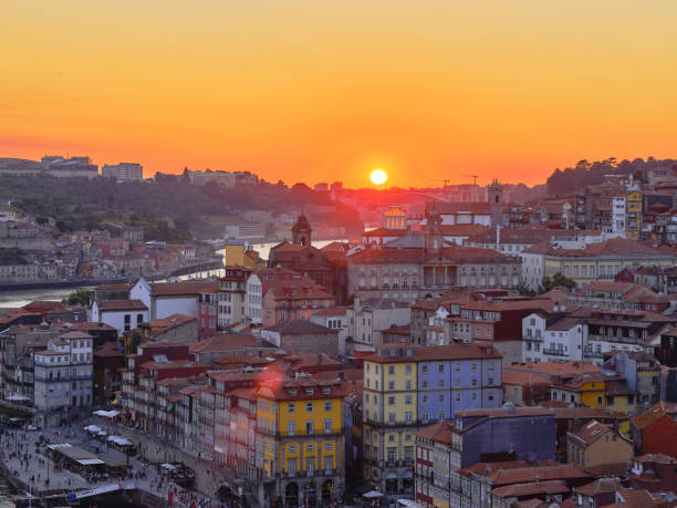 Sunset over the Douro river seen from the Jardim do Morro, a verdant hillside area, accessible by cable car, with benches and a grove of trees and palms at the top, Porto, Portogallo