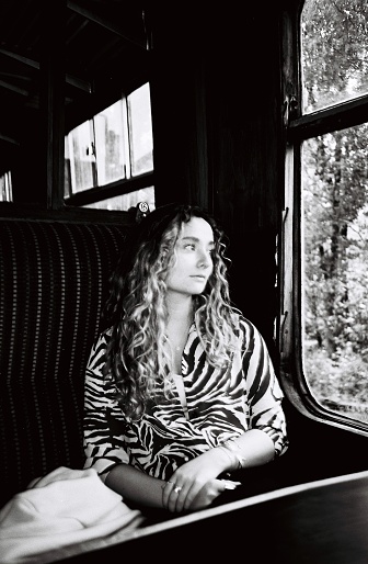 A young woman in first class train carriage, 35mm black and white film, Devon UK.