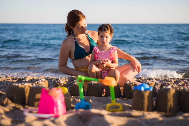 istock Sitting on the beach, on mother's lap. 1725713789