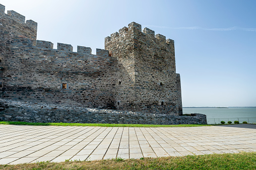 Part of historical Byzantine wall In Istanbul. This photos was taken at sunset. Historical Byzantine wall is towards the blue sky, copy space. There is a round wall in the front.