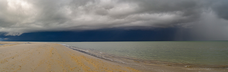 Sunrise at the beach at Texel island with a storm cloud approaching over the Wadden sea at the North point of the island facing the Wadden Sea and Vlieland.